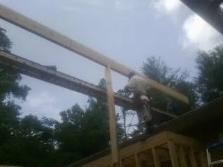 Carpenter setting a ridge beam over a new addition frame — Ice Dam Removal by Roofing Brothers in Warren