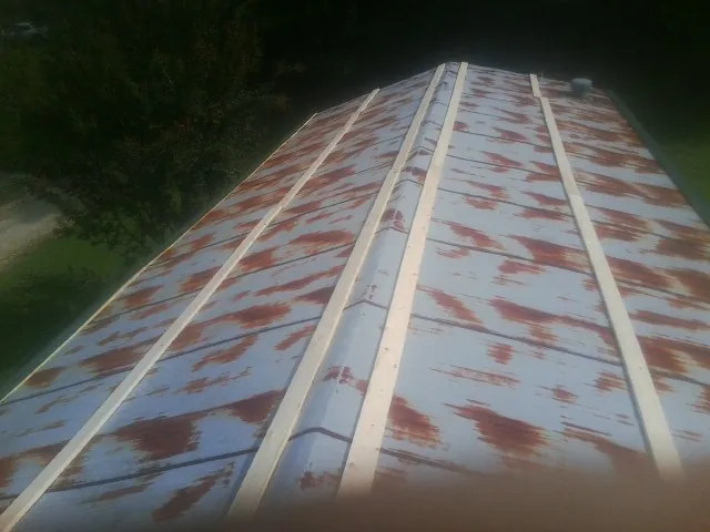 Rusted metal roof panels with new wood purlins before replacement — Storm Damage Roof Repair in Warren by Roofing Brothers